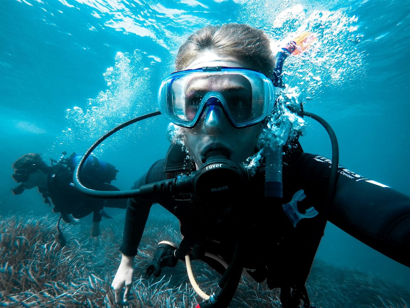 Junger Taucher unter Wasser mit Blick in die Kamera